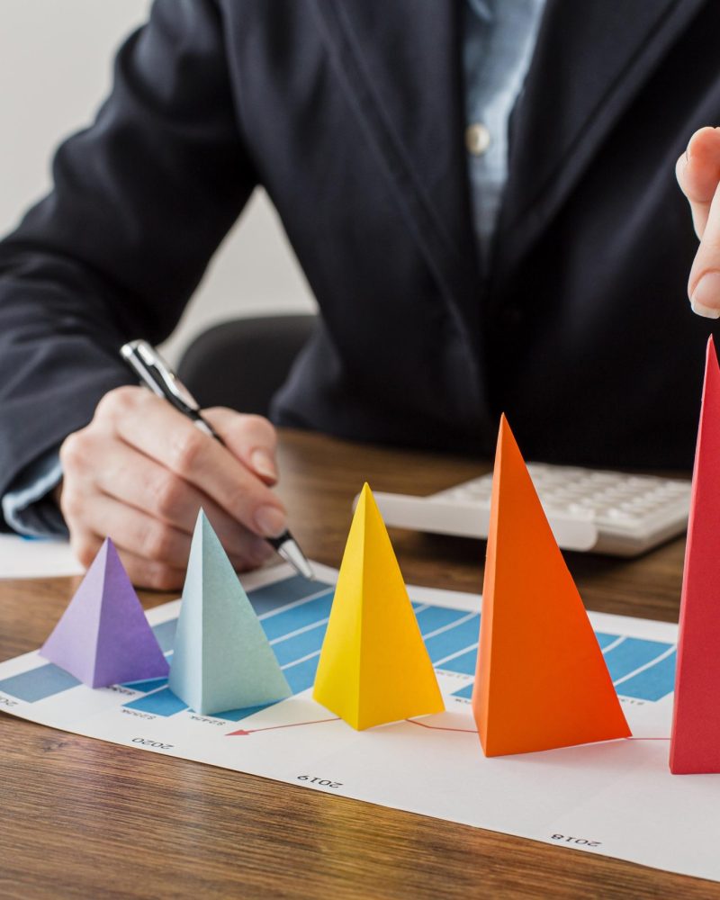 front-view-businessman-with-colorful-cones-representing-growth